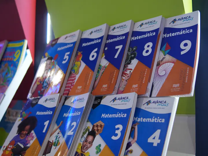Livros de Matemática da Coleção Avança Mais na prateleira do estande